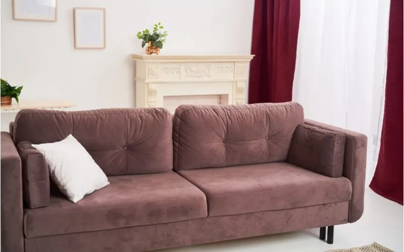 Dark brown couch with cream accents and off-white walls that go together very well