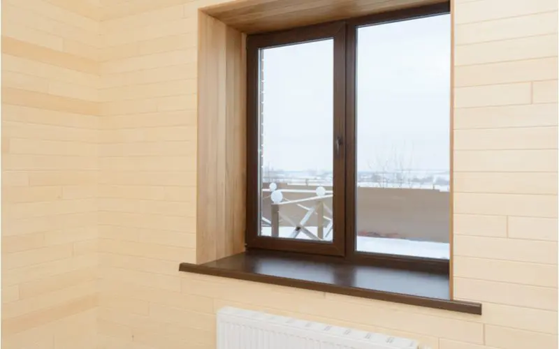 Picture showing the standard window height from the floor with a double framed window with a mahogany shelf