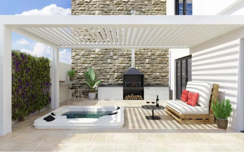 White vinyl pergola idea that covers an in-ground whirlpool and a bench made out of pallets attached to a modern white house