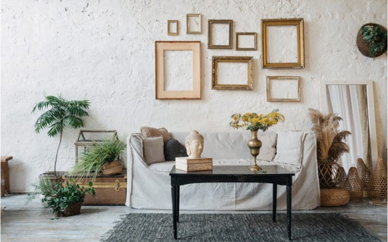 Above couch decorating ideas with lots of gold picture frames above a shabby covered couch