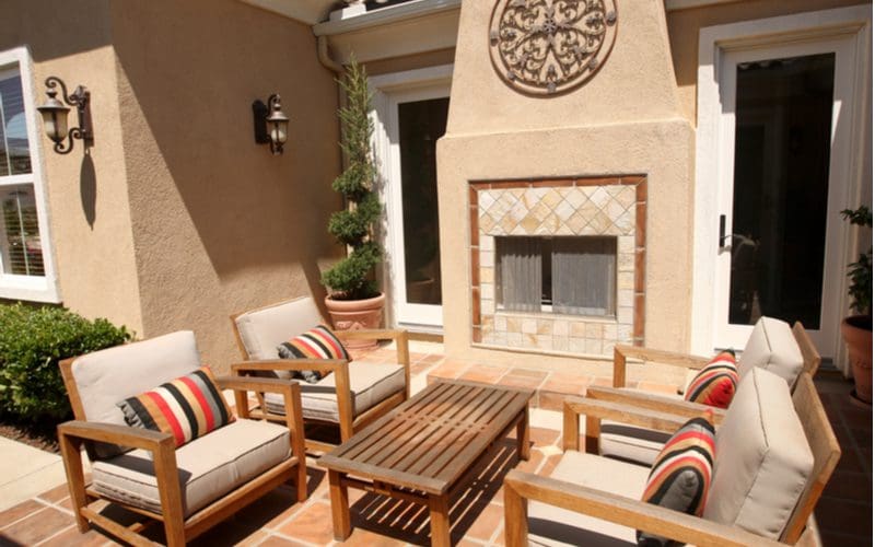 Image of a Spanish-style fireplace tile idea in an outside stucco-lined chimney that overlooks a terra cotta paver patio