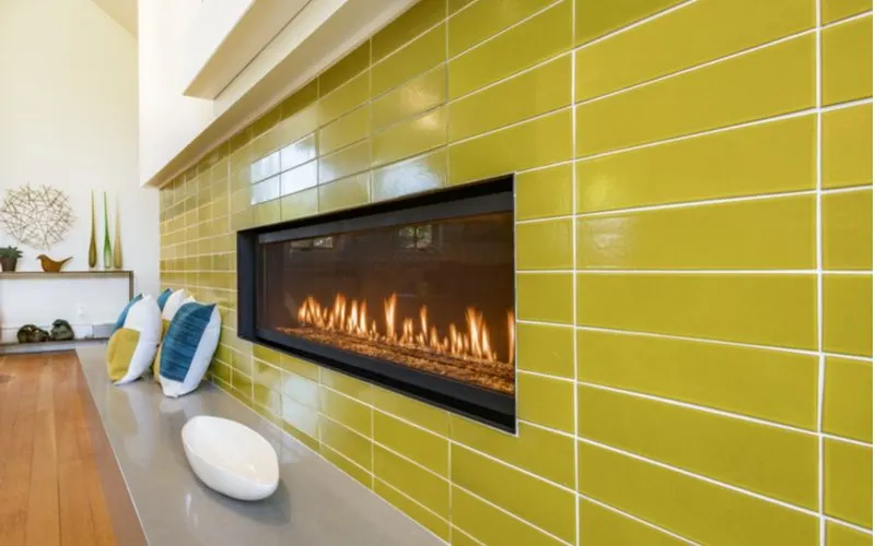 Chartreuse fireplace tile idea with large rectangular tiles alongside a gas ventless fireplace