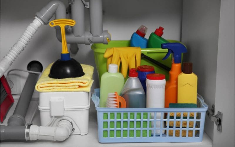 Storage idea for small bathrooms that uses plastic containers and baskets to store cleaning products