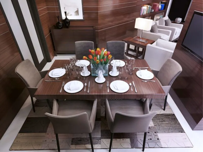 Grey leather, one of the best types of fabric for dining room chairs, on a dining set around a fake wood dining room table
