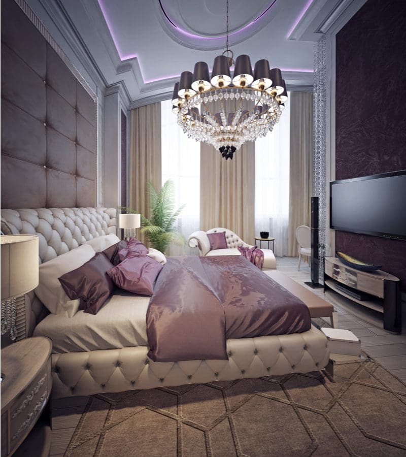 Art deco style aesthetic bedroom idea with a gorgeous crystal chandelier above a leather bed frame with lots of old Hollywood style décor