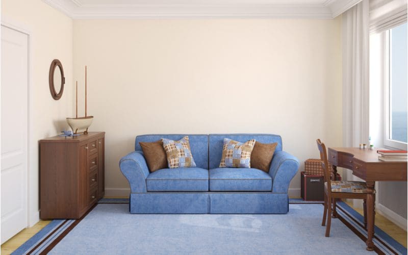 Couch in bedroom idea featuring a bright blue couch against the opposite wall, as viewed from the foot of the bed