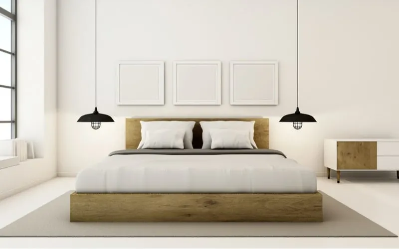 Men's bedroom idea with a white bed frame with white accents next to a white built-in seat bench by the window