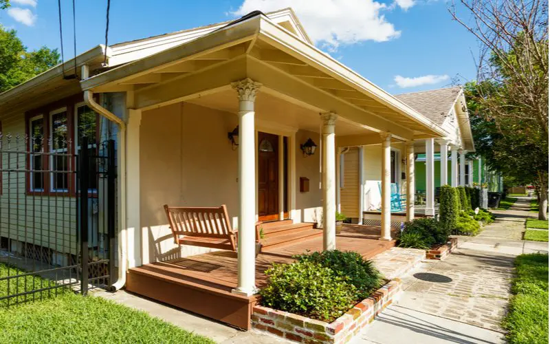 Image of a porch overhang and roof in the form of a colonnade on the front of a shotgun-style home in New Orleans 