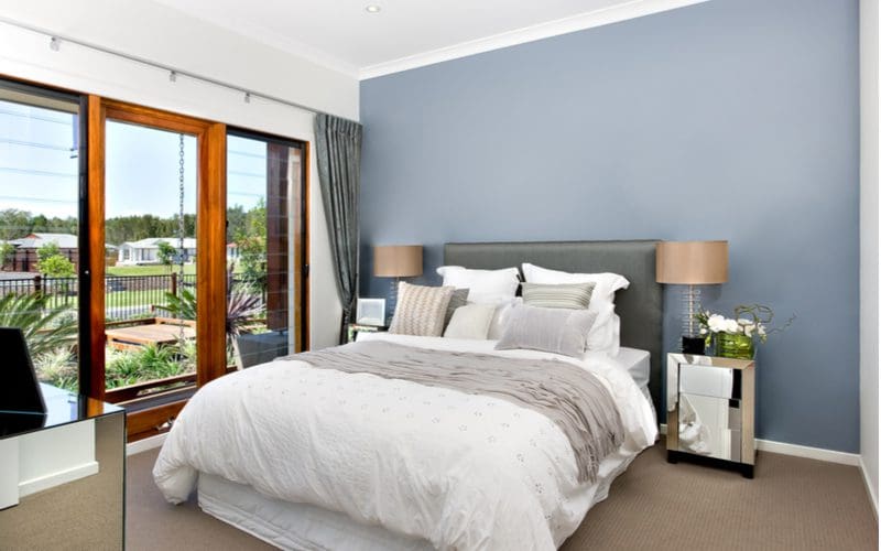 Steel grey wall with natural wood trim around the windows for a piece on grey bedroom ideas