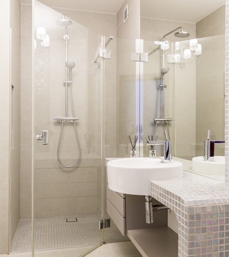 Modern glass shower door with a floating vanity and sink basin below a big rectangular mirror