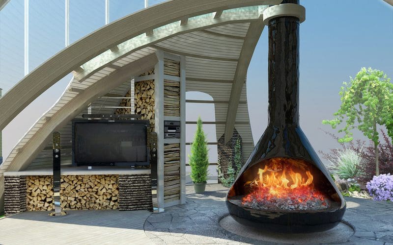 A wood burning fire pit with a big smoke stack in a kettle-style model next to a modern and expansive concrete and wood patio