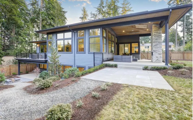 Sloped metal porch overhang and roof idea pictured on a spacious and modern-style mid century modern home in the Northwest US
