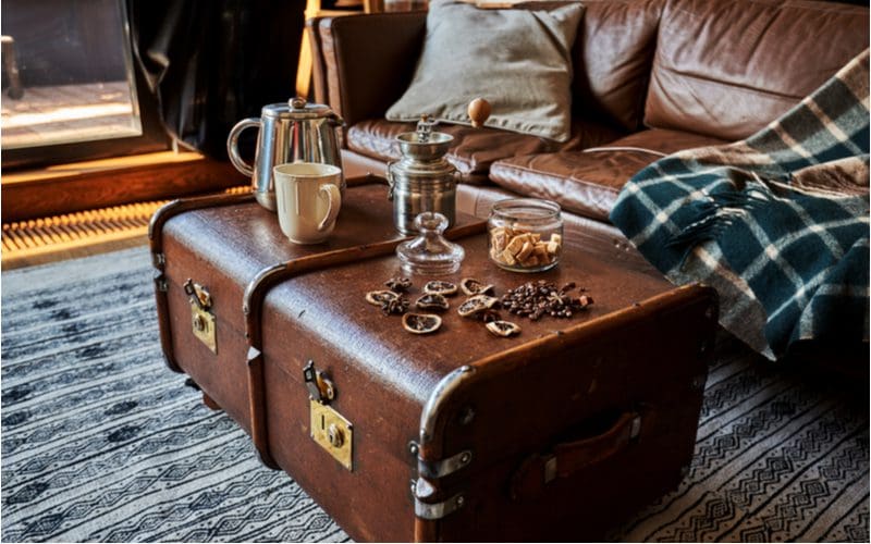 Brown leather trunk acting as a table next to a brown leather couch for a man cave idea