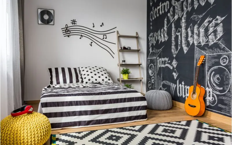 For a product roundup on cool things to put in your room, a well-decorated bedroom with a chalkboard wall decorated with lots of cool stuff
