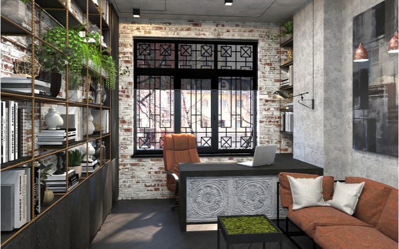 Brick and cement-walled office with lots of metal shelving for a piece on man cave ideas