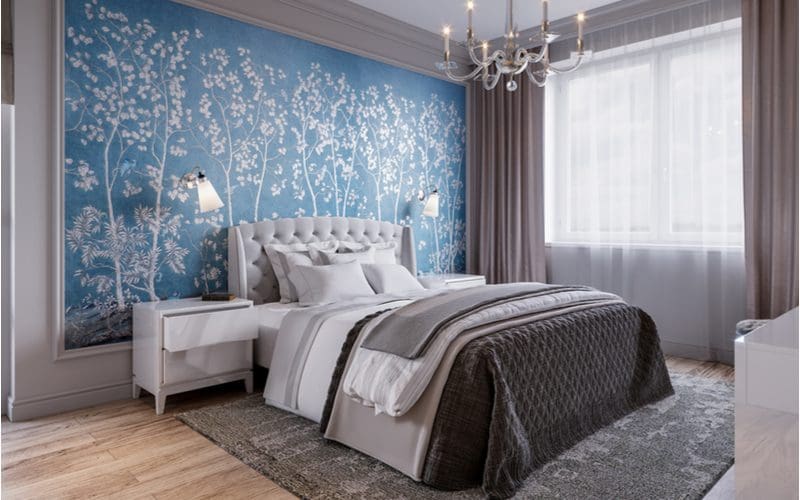 Grey bedroom idea with a giant blue mural with floral themes above the bed and with a grey rug and grey curtains