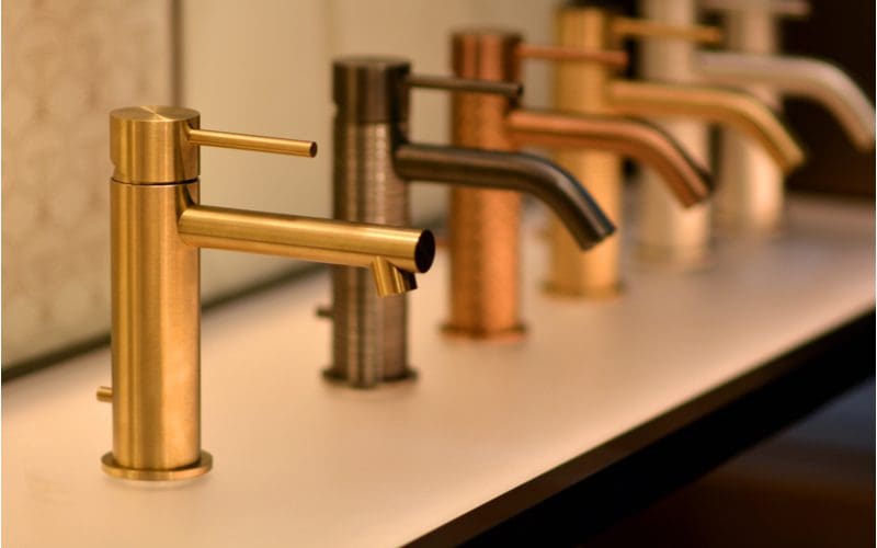 White and gold bathroom idea showing the various shades of gold faucets available mounted on a white vanity top