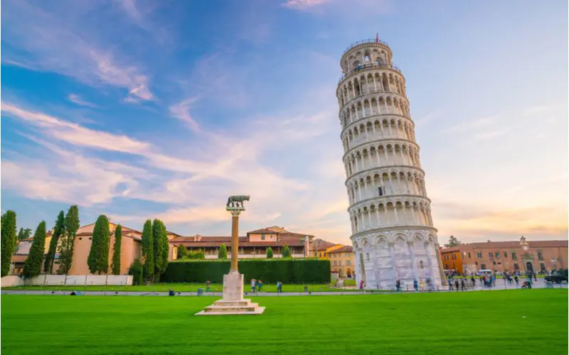 Roundup of the world's most famous buildings featuring the leaning tower of Pisa depicted against a calm blue sky in the late afternoon