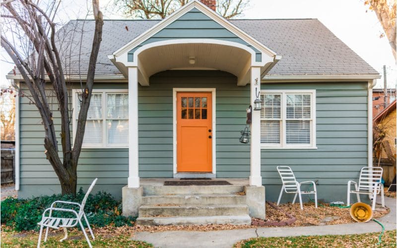 Gray house and bold orange door for a fall-themed front door color for gray houses