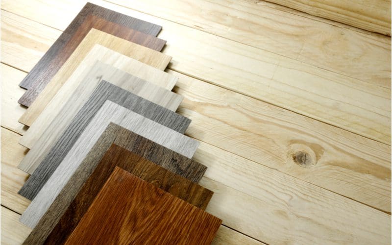 Samples of hardwood flooring laid out on an unstained hardwood floor