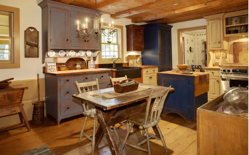Tricolor rustic cabinets mixing grey, blue, and natural wood in a log-cabin inspired home