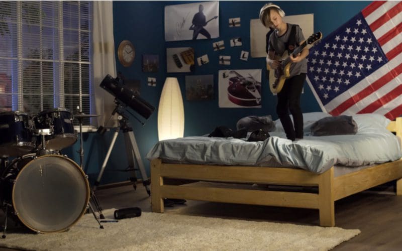 Musically inspired teen boys' room decorations on the walls with a drum set and American flag