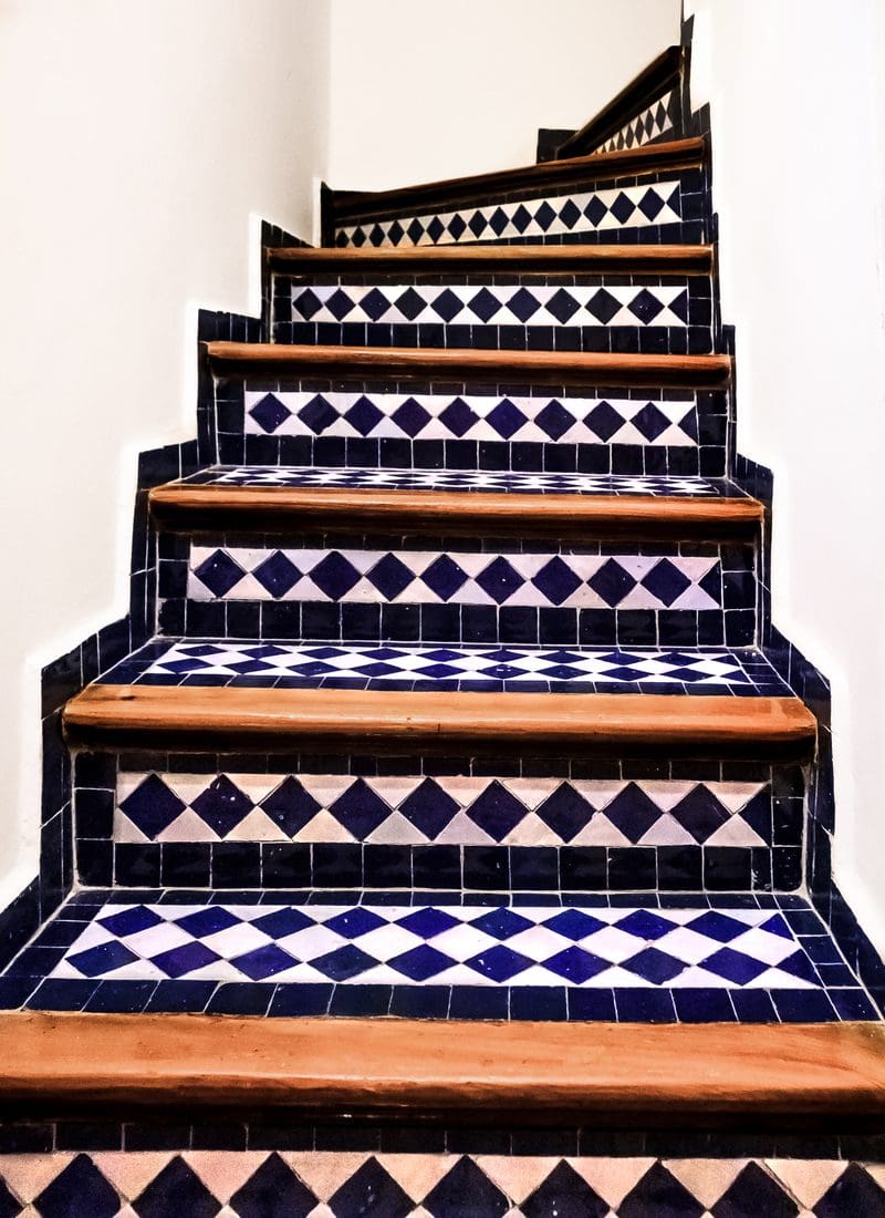 Spanish-style ceramic tiles on the bottom and the sides of a staircase for a piece on decorating ideas for stairs
