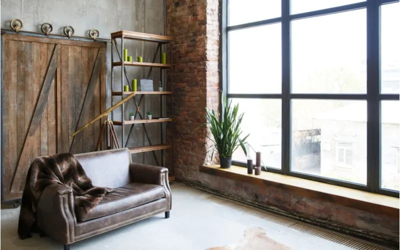 Bachelor pad idea in an industrial style with exposed brick and a sliding farmhouse door with exposed rollers