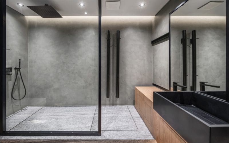 Doorless Walk In Shower Idea featuring a Gray Marble and Glass Partition and black accents throughout the marble and natural wood bathroom