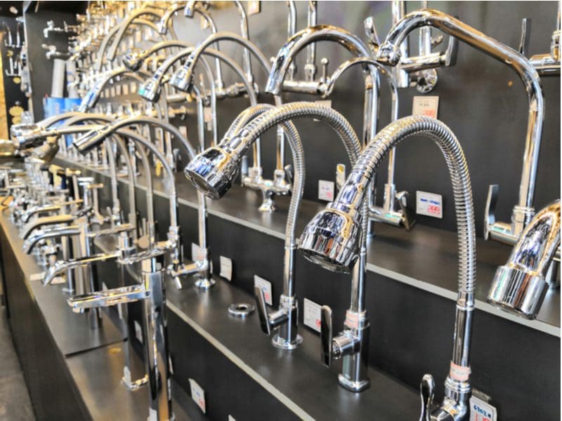A number of faucet brands sit among their competitors on a matte black wall