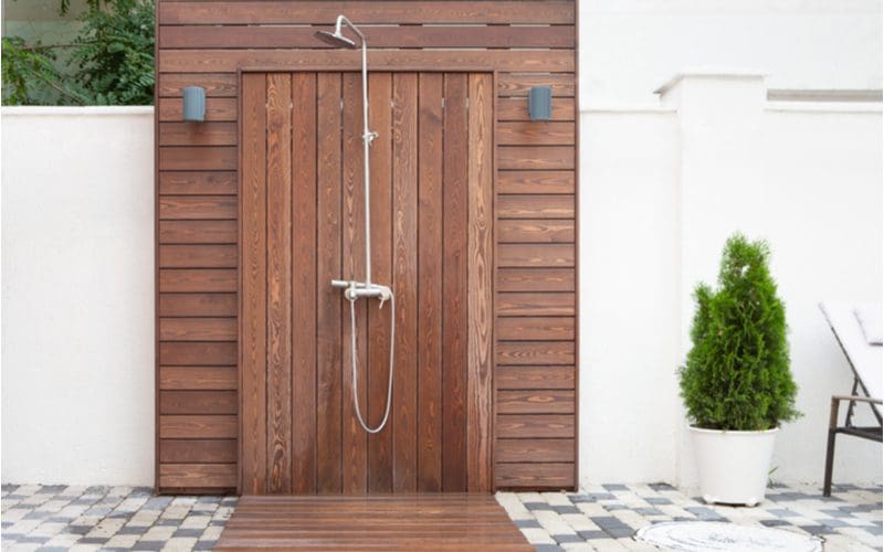 Wooden Outdoor doorless walk in shower idea featuring a shower and surround made from simple stained wood slats