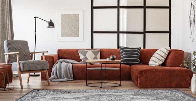 Featured image for a piece titled how to pick throw pillows for brown couch featuring a brown suede couch with grey and white throw pillows in an industrial-modern room