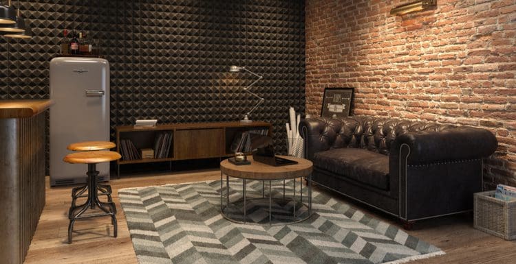 Featured image for a piece titled Bachelor Pad Ideas featuring a rustic art deco style living room with a retro fridge, triangular textured walls, and a brick wall in back of the leather couch