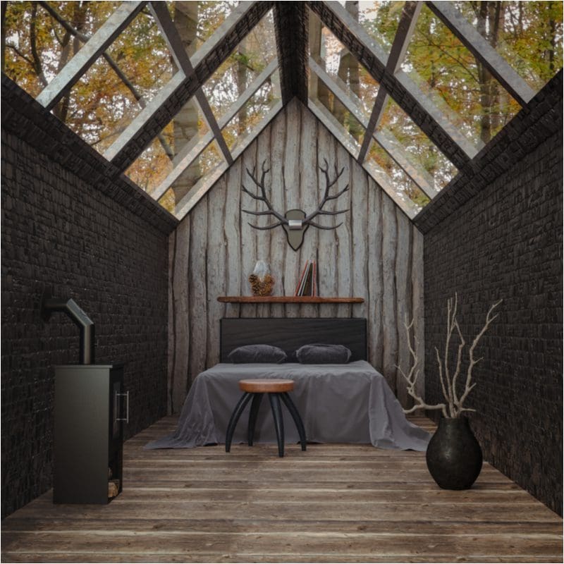 Interior cabin idea themed as a hunting lodge with a bed and wood burning stove in a brick room and an angled glass roof as the ceiling