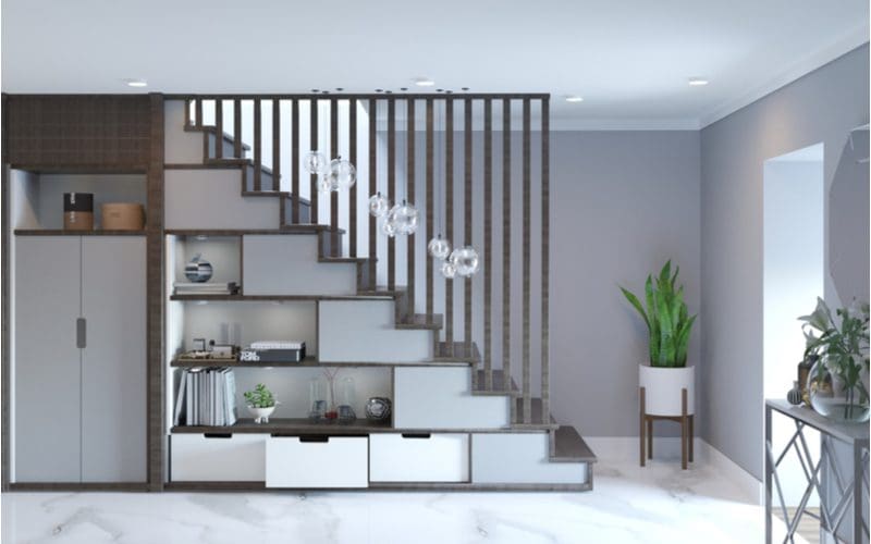 Stair decorating idea featuring built-in shelving below the staircase as part of the wall