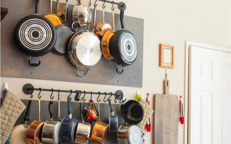 Pots and pans mounted on the wall from a pot rack as kitchen wall decor