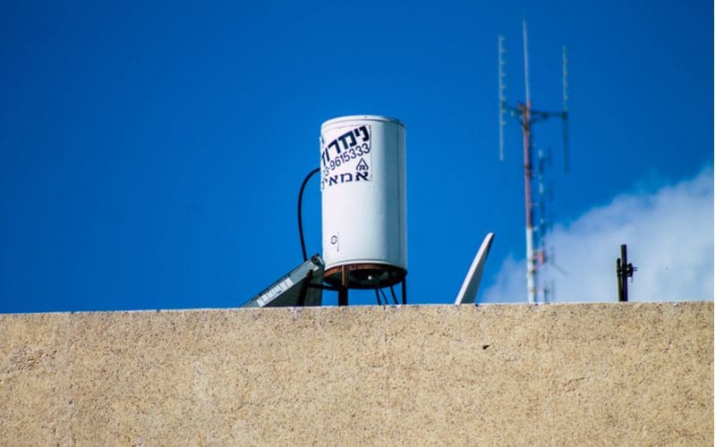 Water heater outside on a roof in Israel next to a cell tower