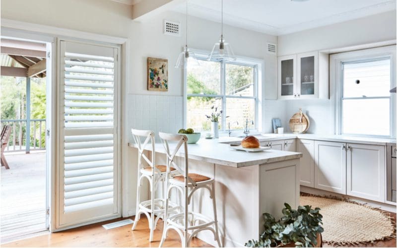 For an idea for window treatments for sliding glass doors, plantation shutters attached to the door frame in a kitchen
