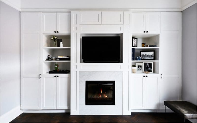 Built-in wall living room toy storage idea featuring white cabinets