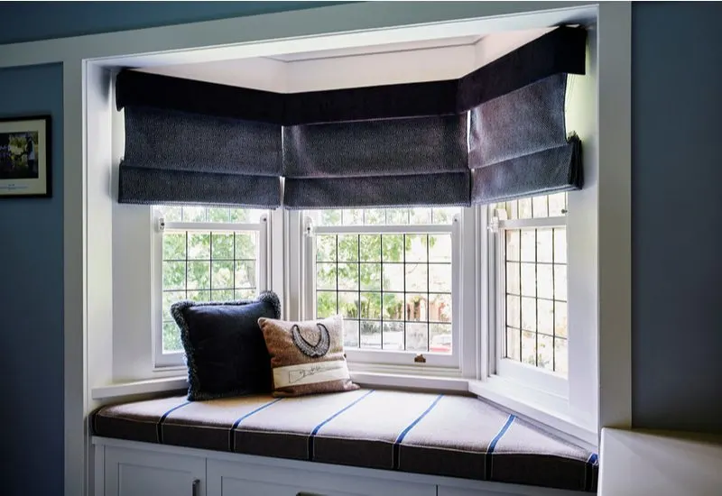 Bay window curtain idea featuring several panel-style curtains that pull up above the windows