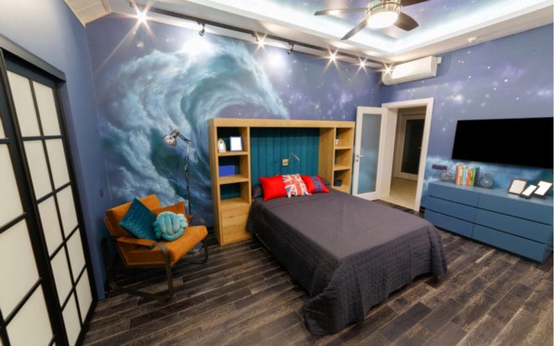 Teen boy room decorating idea with murals of waves and galaxies on the walls and ceiling