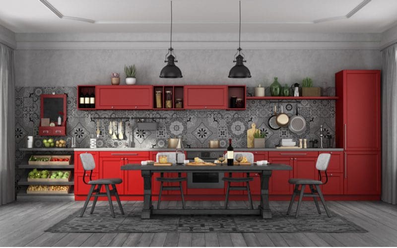 Rustic cabinets in a kitchen with the doors painted red with red accents throughout and Spanish-style mosaic backsplash