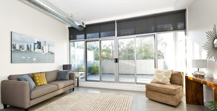 Featured image for a piece titled Sliding Glass Door Window Treatments featuring a roller shade that's partially retracted