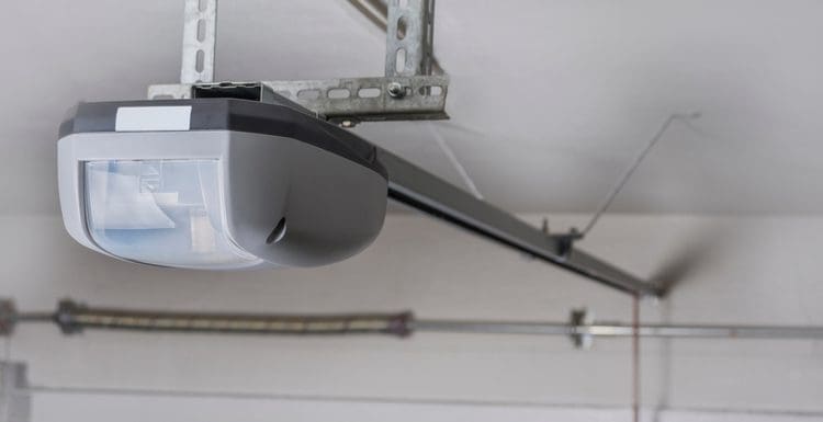 Liftmaster garage door opener price featured image showing an electric belt-driven garage door opener mounted on the ceiling of a garage