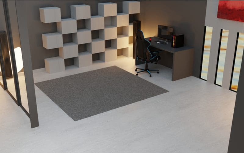 Futuristic design gaming setup idea featuring a grey floor with cube shelves to the left of the chair