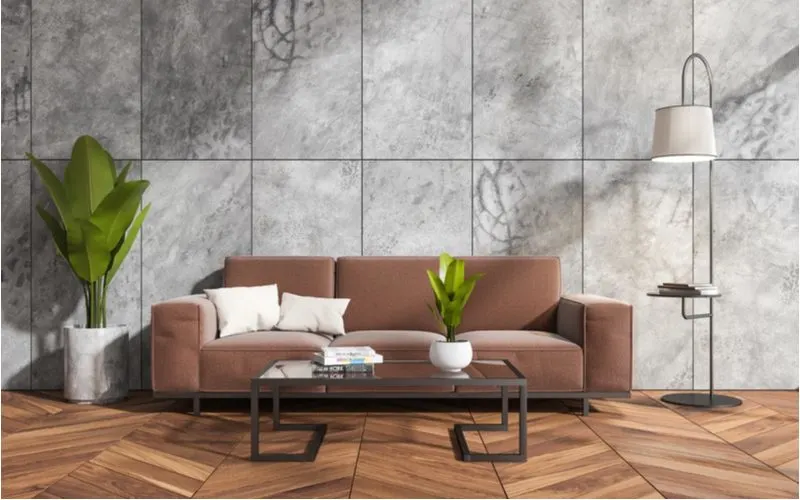 White throw pillows on a brown couch in a transitional-style living room with grey marble-looking walls