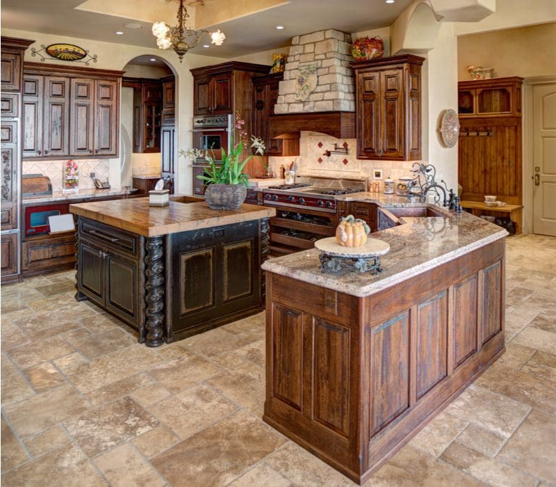 Rustic cabinets made of worn walnut in a home with light grey granite and stone accents throughout