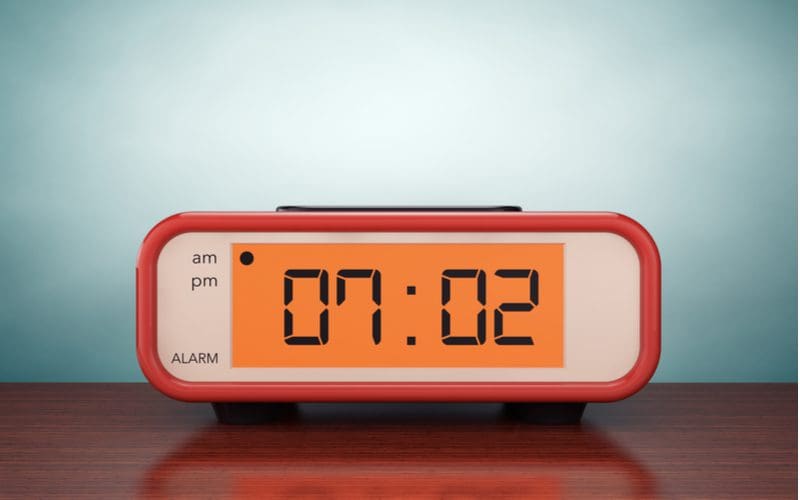 Old style red digital clock sits on a desk for a piece on types of clocks