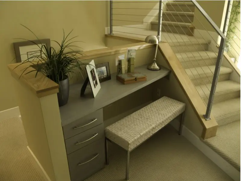 Home office design idea featuring a desk that's built into the staircase in sort of nook