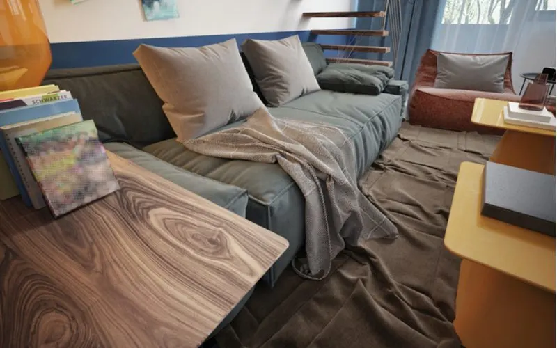 Teen boy's room decorating idea with a lounge look featuring a futon-style bed with gunmetal sheets below a floating wooden staircase